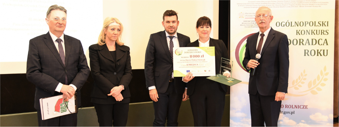 Dorota Piękna-Paterczyk z WODR drugą najlepszą doradczynią w Polsce! Pięć elegancko ubranych osób pozuje do zdjęcia. Druga od prawej stoi kobieta, która trzyma statuetkę i czek.
