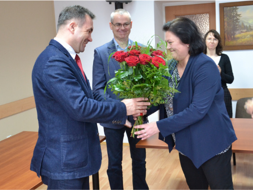 Jacek Sommerfeld odbiera kwiaty z rąk przedstawicielki pracowników WODR. W tle stoją dwie osoby.
