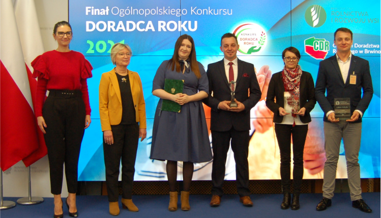 Najlepsi doradcy rolniczy w kraju odebrali nagrody za udział w konkursie Wnętrze pomieszczenia. Doradcy rolniczy stoją z nagrodami wręczonymi za konkurs Doradca Roku. Obok nich stoją przedstawiciele Ministerstwa Rolnictwa.i