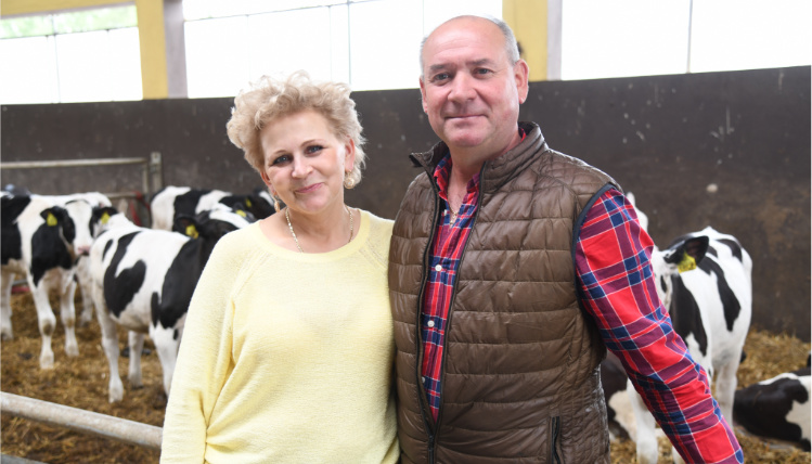 Teresa i Mariusz Smolarkowie, zwycięzcy AgroLigi 2021 W oborze przy boksie z krowami stoi kobieta i mężczyzna, którzy obejmują się i uśmiechają. Za nimi są krowy.