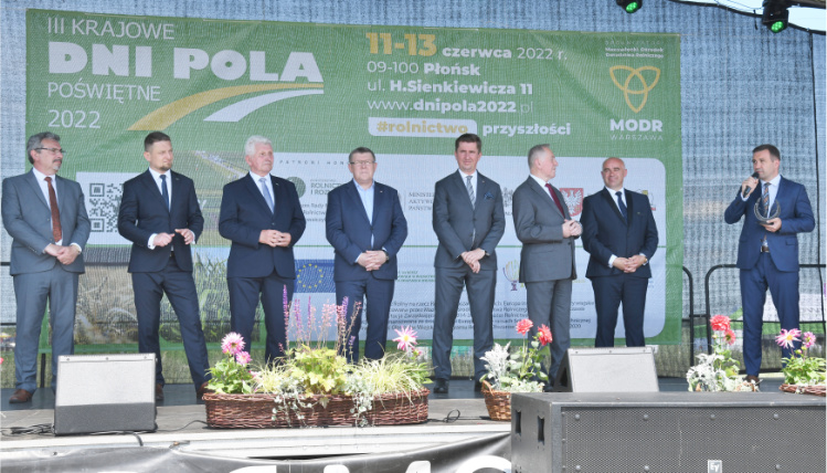 4. Krajowe Dni Pola odbędą się w Sielinku w dniach 1-5 czerwca 2023 Na scenie w rzędzie stoi kilku mężczyzn w garniturach. Jeden z nich przemawia.
