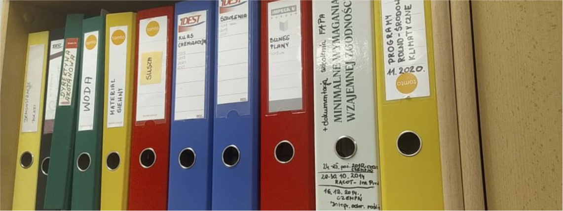 Biurokracja w gospodarstwach rolnych jest uciążliwa, ale obowiązkowa Zbliżenie na półkę z segregatorami z dokumentacją.