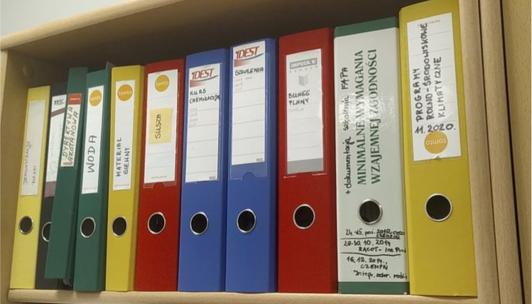 Biurokracja w gospodarstwach rolnych jest uciążliwa, ale obowiązkowa Zbliżenie na półkę z segregatorami z dokumentacją.