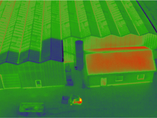 Skan termowizyjny budynku. Cały budynek podświetlony jest kolorem zielonym, a na dachu, czyli w miejscu o największym oddziaływaniu energii, widać kolor czerwony.