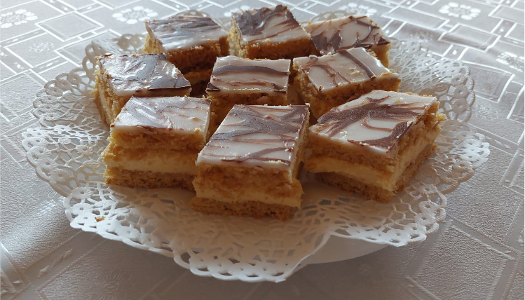 Mazurek to tradycyjne ciasto na Wielkanoc (zdjęcie: Monika Szczepaniak) Na talerzu, na białej serwetce leżą pokrojone kawałki mazurka wielkanocnego oblanego lukrem i czekoladą.